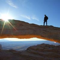 Man standing on an arch in the desert